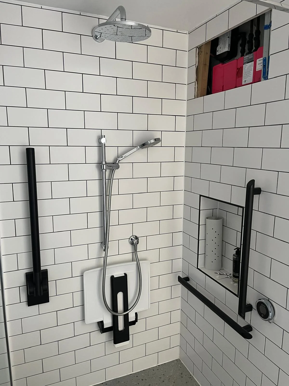 Completed accessible shower area with controls and support fittings installed