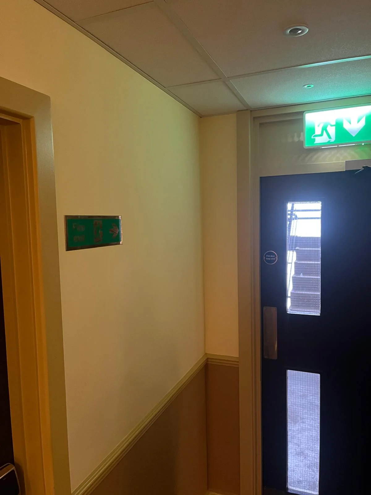 Signed commercial fire exit route checked during maintenance