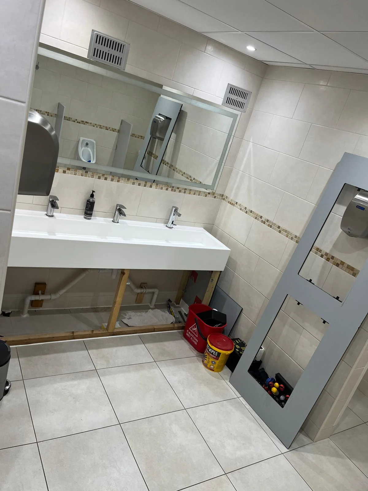 Completed commercial washroom basin with taps and waste connected