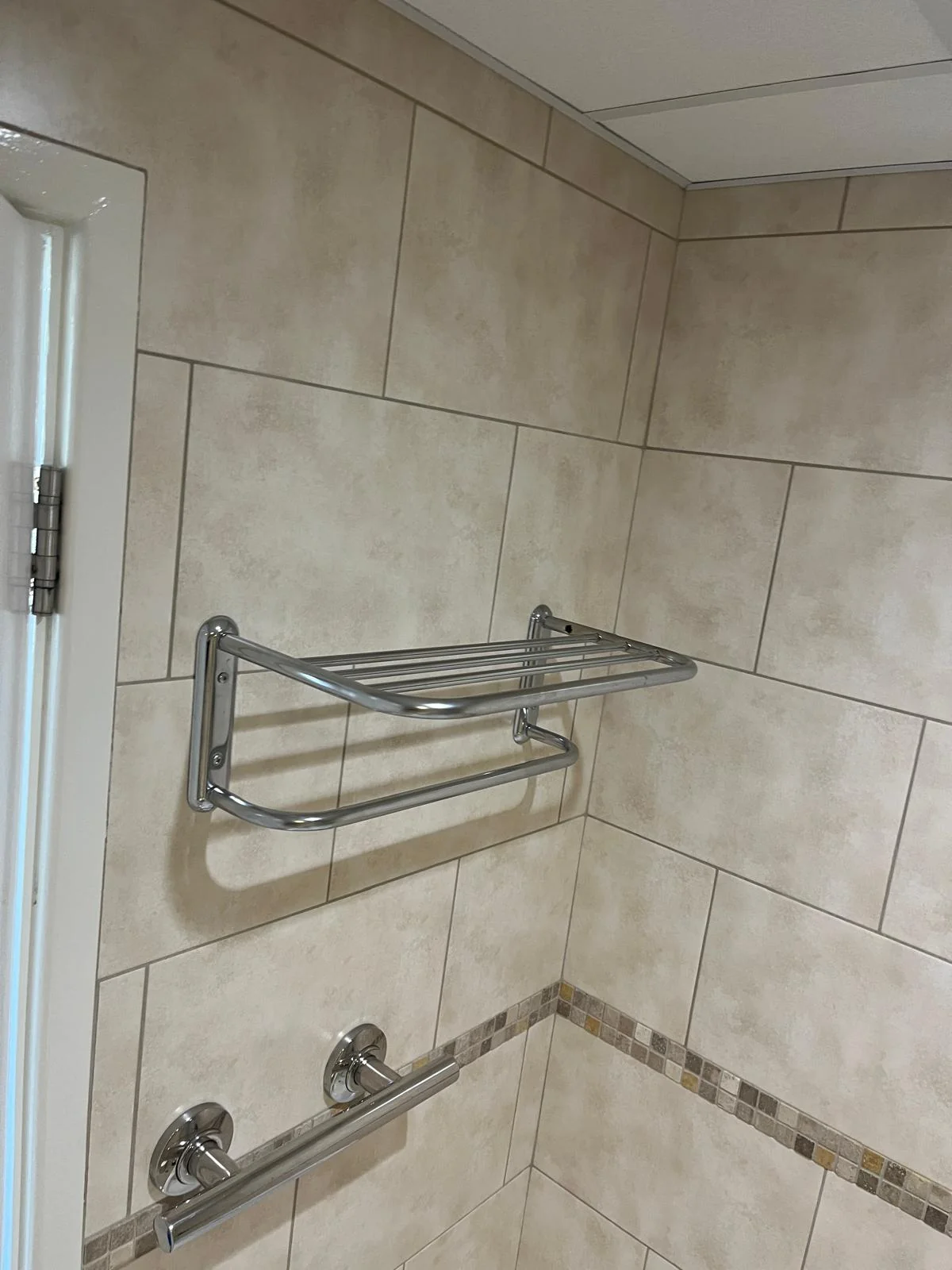 Shower rail and storage fitting installed on tiled wall