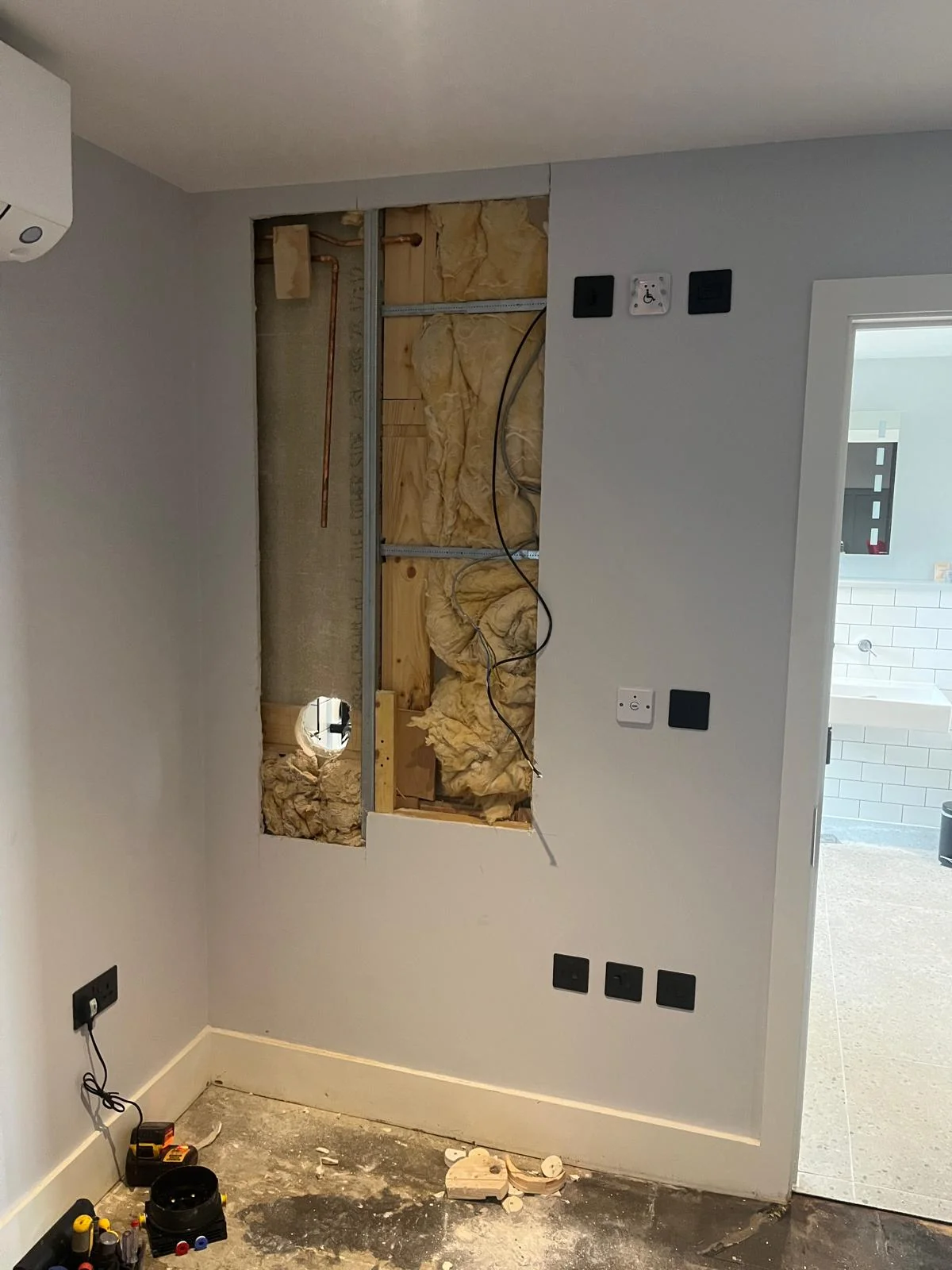 Pipework and cabling exposed during shower valve installation