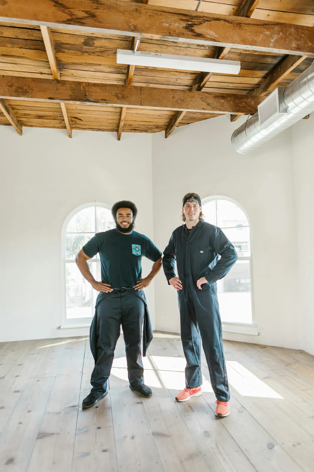 Two maintenance operatives standing inside a refurbished commercial room