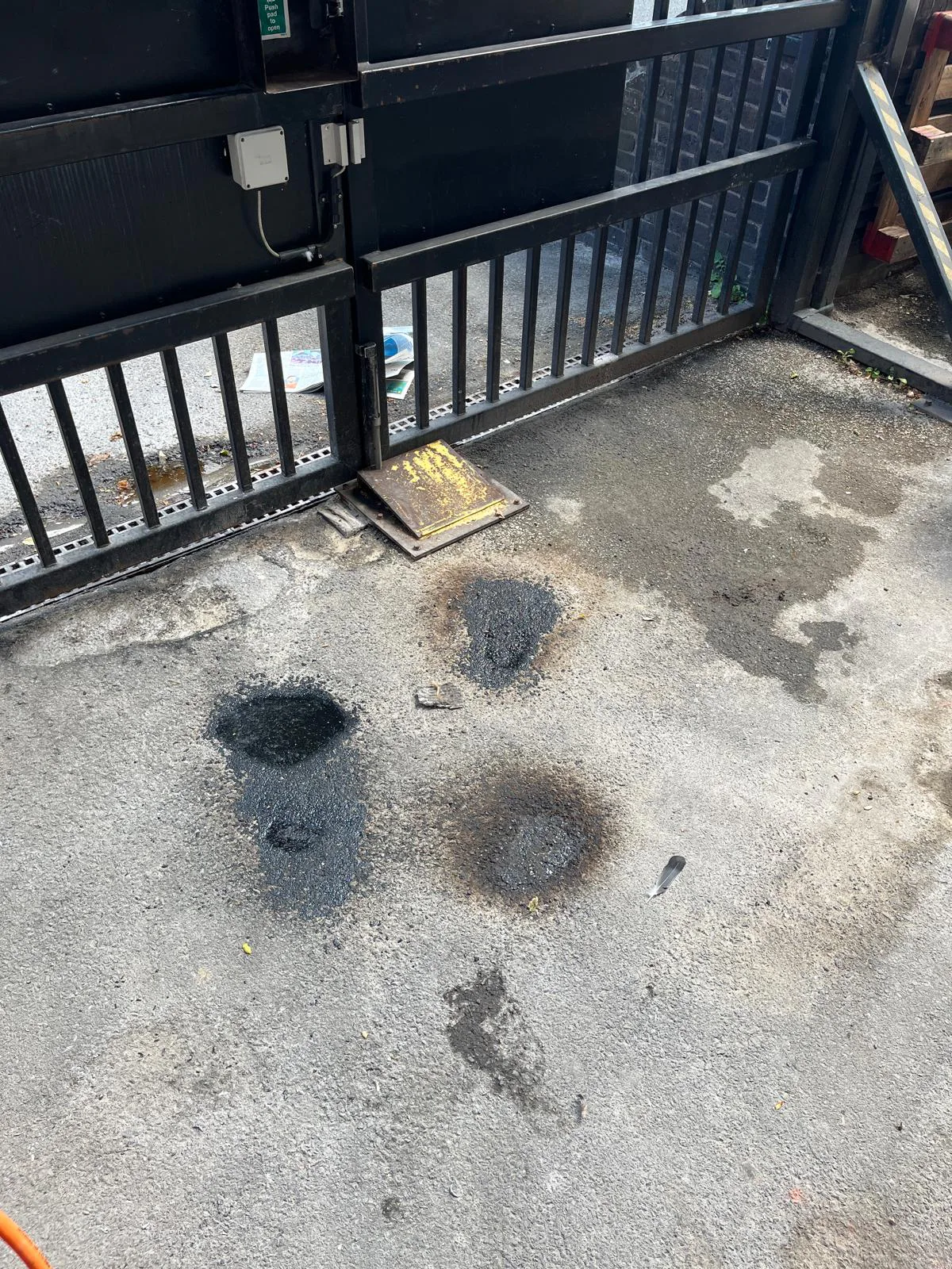 Tarmac pothole repairs at gated access area near Sidcup