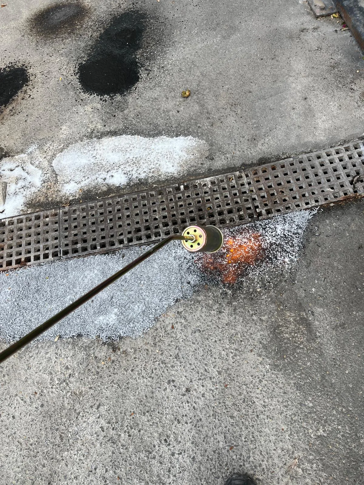 Tarmac surface repair beside external drainage channel